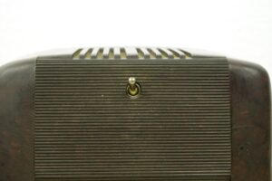 Close-up of the back of a brown plastic radio with a centered toggle switch and horizontal vent slots.