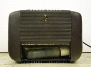 Antique brown plastic radio shown from the back with a ribbed panel, a switch near the top, and the bottom light compartment visible open.