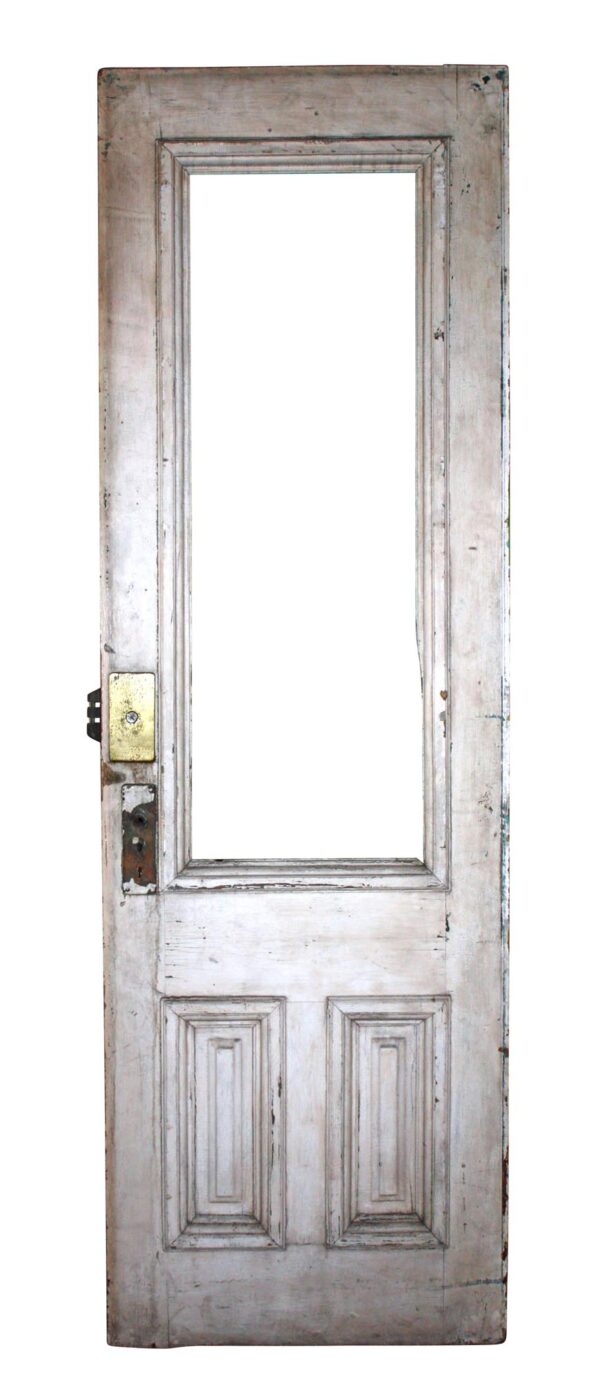 White entry door with one tall glass opening and two lower raised panels, shown without the glass inset and with visible hardware on the left side.