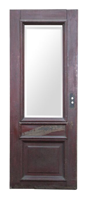 Antique entry door with one narrow beveled glass panel and two wood panels, shown in dark wood tone on one side with a visible hardware plate.