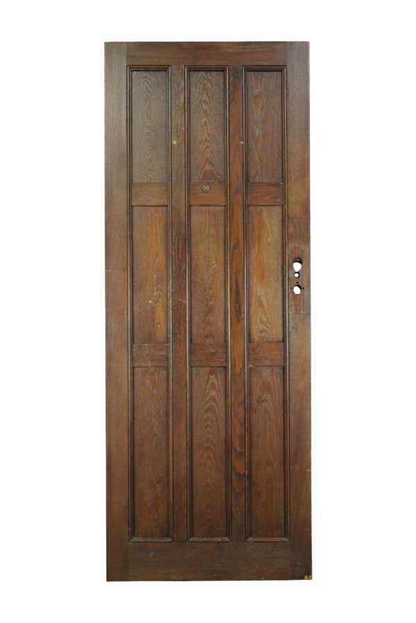 Arts and Crafts oak entry door with nine panels and a dark wood tone, shown front-facing with hardware holes visible on the right side.