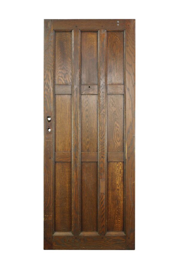 Arts and Crafts oak entry door with nine panels and a dark wood tone, shown front view with visible hardware openings on the left side.