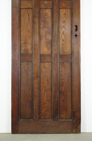 Arts and Crafts oak entry door with nine panels, shown front on with visible aged wood grain and hardware cutouts on the right side.