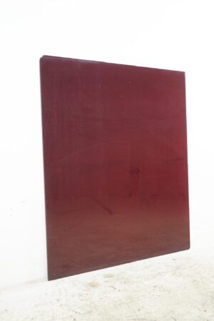 Red structural glass sheet shown upright with a small broken corner and chipped edges.