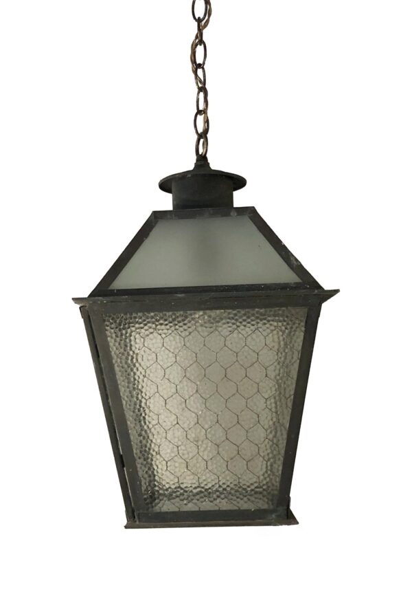 Industrial hanging lantern with a black finish, clear pebbled chicken wire glass panels, and a chain hanger.