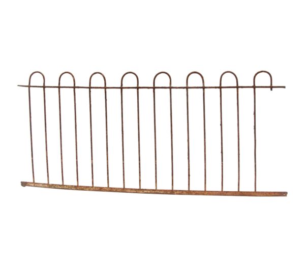 Heavily rusted wrought iron fence section with looped bars, shown with a missing section on one end.