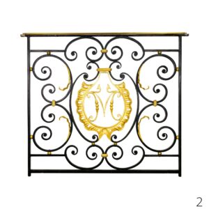 Decorative wrought steel banister panel with a centered gilt brass M monogram and scrollwork.