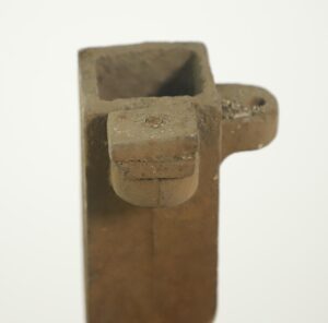 Close-up of a cast iron corner post with a twisted spiral design and visible wear, shown from the top and side.
