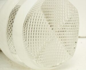 Close-up of a semi flush mount light with a white and clear glass shade.