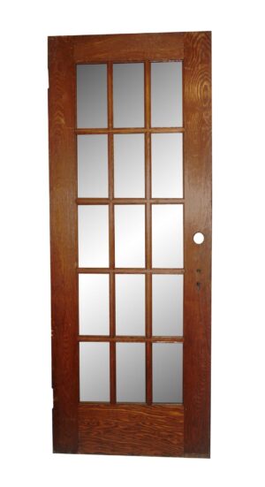 A 15-lite oak French door with a missing glass pane in the lower right section.