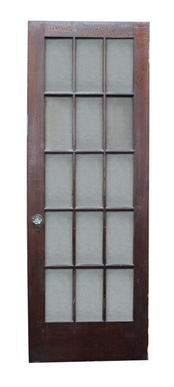 Antique wooden door with 15 textured glass panels and an original glass doorknob.