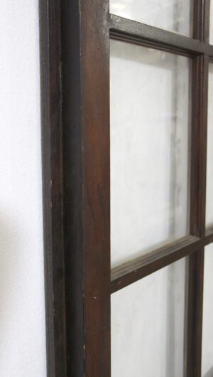 Close-up of a dark wood tone French door showing part of the 10-lite glass panel grid and attached lip.