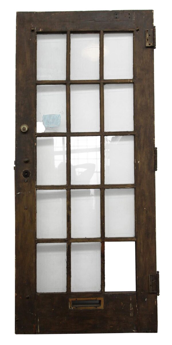 Dark wood tone French door with 15 glass panes, one pane missing, shown front on.