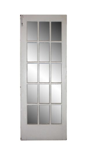White wooden French door with 15 glass panes, shown full length, with some original hardware still attached.