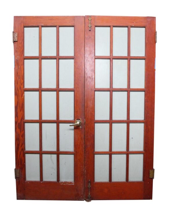 Vintage wood double French doors with 15 glass panels per side and visible hinges and handle.