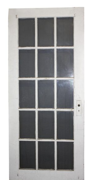 Vintage white wood French door with 15 glass panes and two broken panes visible.