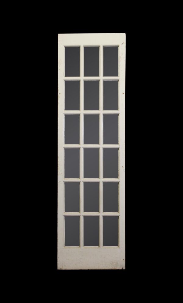 Vintage white French passage door with 18 glass panes in a tall narrow frame.