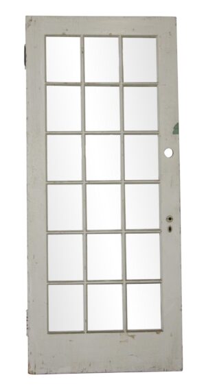 Vintage white painted wooden door with 15 glass lites, shown front on with visible age-related wear and hardware openings.