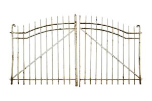 Pair of white wrought iron driveway gates with a curved top, vertical bars, and curled end posts, shown front on with visible rust.