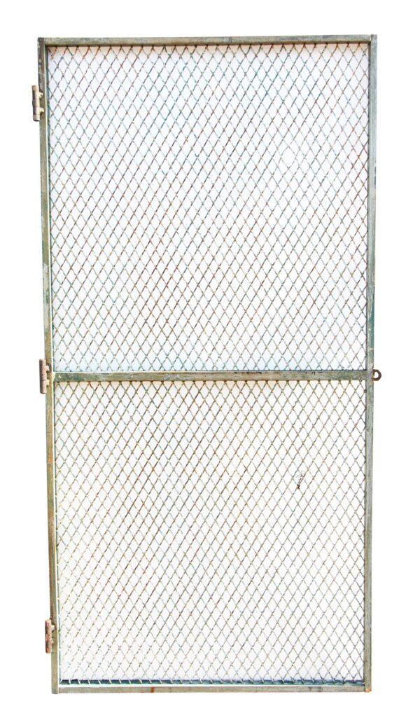Vintage galvanized steel door grate with woven mesh, hinge hardware on the left, and a horizontal divider across the middle.