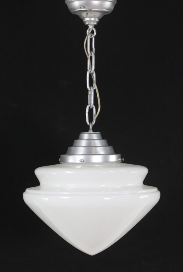 Mid century pendant light with a tiered milk glass shade and silver-painted steel fitter hanging from a chain.