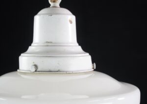 Close-up of the white schoolhouse pendant light’s top canopy and chain mount, showing the painted metal surface and small wear marks.