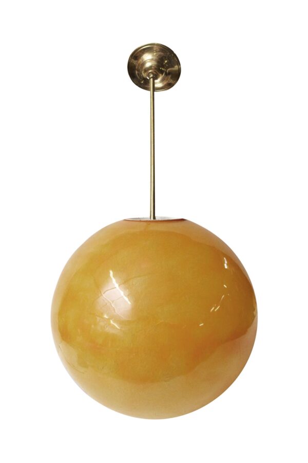 Mid-century pendant light with a large orange ball shade and a slim brass stem mounted to a round ceiling canopy.