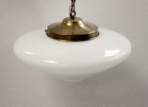 Cone-shaped schoolhouse pendant light with a white milk glass globe and antique brass chain fitter.