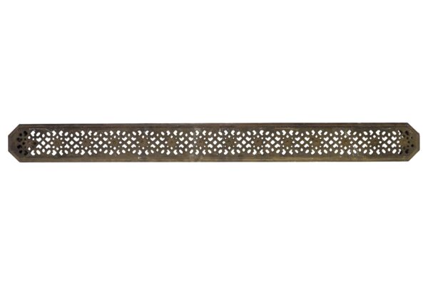 Long cast iron heating grate with an ornate perforated pattern and worn edges shown in full length.