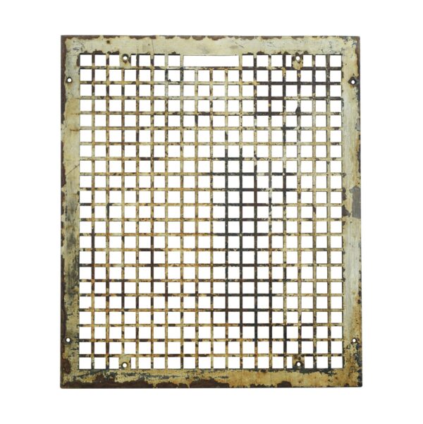 Rectangular cast iron wall grate with a dense square grid, surface rust, and mounting holes around the edges.
