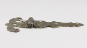 Antique 8.5-inch ice box hinge shown in profile, with a decorative leaf-shaped plate, central barrel, and mounting holes, finished in nickel over bronze with visible surface wear.