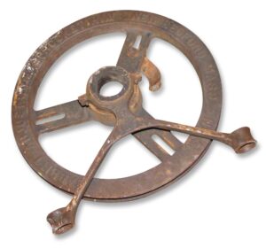 Antique cast iron chain sprocket with a hand crank arm, shown in a side view with visible rust and wear.