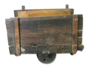 Antique factory cart with open wooden sides and a cast iron wheel, shown from above with dark wood tone and black finish visible.
