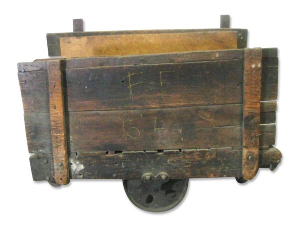 Antique factory cart with open wooden sides and a cast iron wheel, shown from above with dark wood tone and black finish visible.
