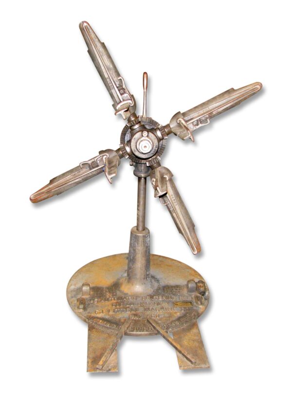 Vintage cast iron centering machine with five feed arms and a worn base, shown in a front view.