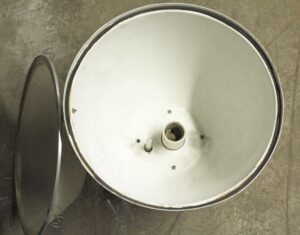 Industrial spotlight with a white interior housing and a ridged lens shown beside it, viewed from above.