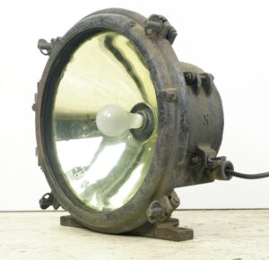 Industrial steel flood light with a clear glass reflector and exposed bulb, shown in a side view with wiring extending from the housing.