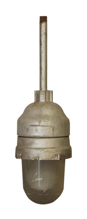 Industrial pendant light with a gray metal housing and ribbed glass lens, shown with a long threaded stem.