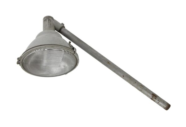 Industrial metal pole spotlight with a long angled arm and ribbed glass lens.