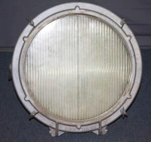 Round industrial spotlight with a ribbed glass lens and aluminum housing, shown from the front.