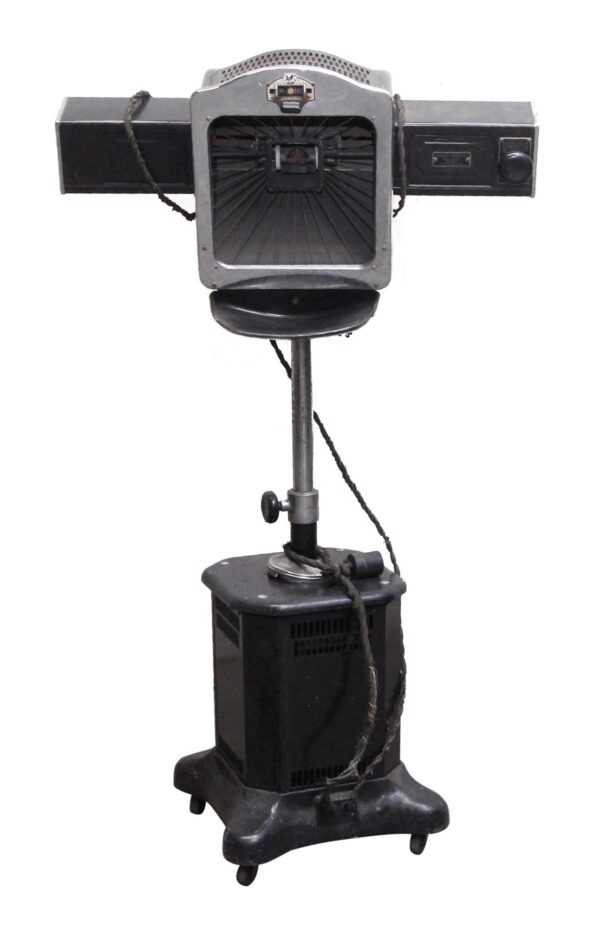 Black therapeutic lamp on a wheeled stand with a large rectangular head, side arms, and a central opening.