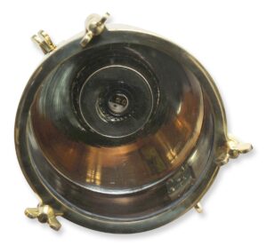 Close-up view of a nautical signal light with a copper finish and brass fittings, showing the front opening and central socket.