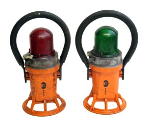 Pair of subway transit lights, shown together with one red lens and one green lens, each mounted in an orange housing with a black handle and stamped MTA NYC.