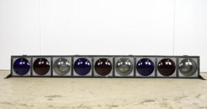 Reclaimed steel frame stage lights with nine round lenses in blue, red, and clear glass, shown in a long horizontal pair with visible vintage wear.