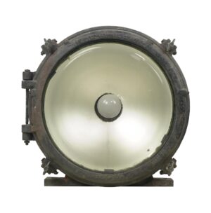 Industrial steel and glass flood light with a clear lens and circular housing shown from the front.
