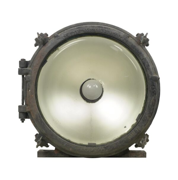 Industrial steel and glass flood light with a clear lens and circular housing shown from the front.