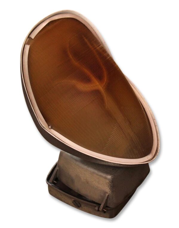 Industrial exterior spot light with a large angled Fresnel glass lens and metal housing.