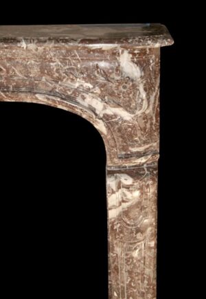 Close-up of a Louis XV marble mantel showing the right side leg, curved opening, and shelf edge.