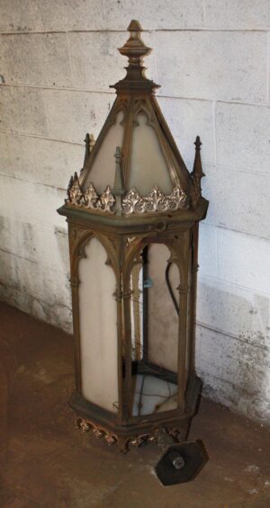Tall Gothic exterior sconce with a pointed top, decorative finial, and arched glass panels shown in full view.