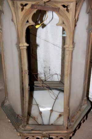 Antique Gothic exterior sconce with cast bronze frame and glass panels, shown with its open interior and visible wiring.